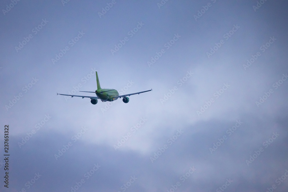 back view of a departing passenger airplane against a gloomy cloudy sky back view of a departing passenger airplane against a gloomy cloudy sky