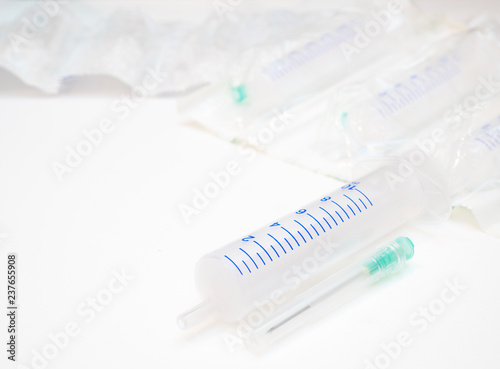low angle shot of medical syringe with needle aside and a pack of syringes blurred on background with copy space on left side