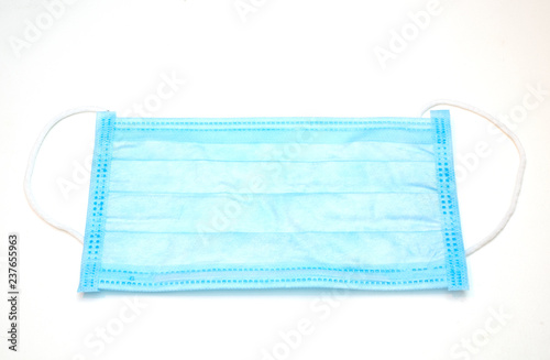 close-up of disposable blue medical face mask on white background
