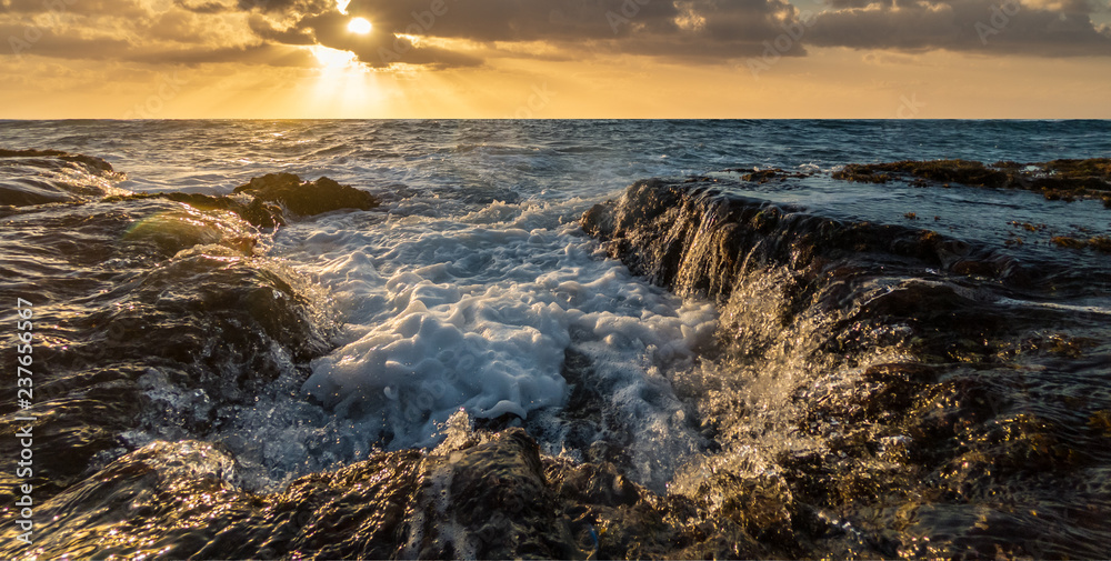 Sea water draining over rocks back into the swirling ocean. Makawehi Bluff, Kauai, Hawaii