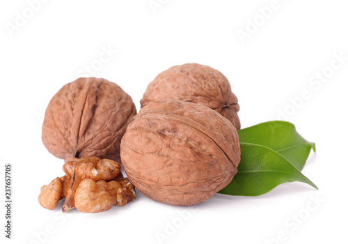 Walnuts in shell, kernel and green leaves on white background