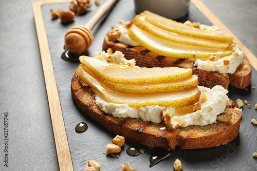 Toasted bread with cream cheese and pear on board