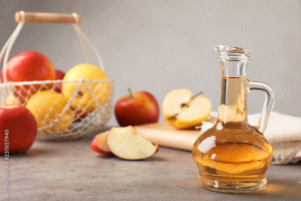 Composition with jug of apple vinegar on table. Space for text Composition with jug of apple vinegar on table. Space for text
