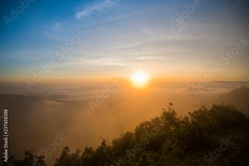 foggy landscape dramatic/ the morning beautiful sunrise mist cover mountain background - forest hill mist fog flow with wind and blue sky