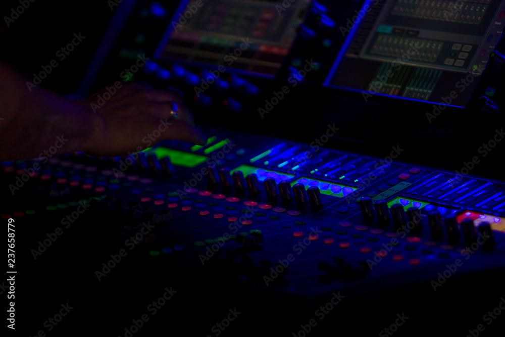 Modern mixing console with backlit iluminated controls by blue led diodes shining in darkness. Unicolor simple photography