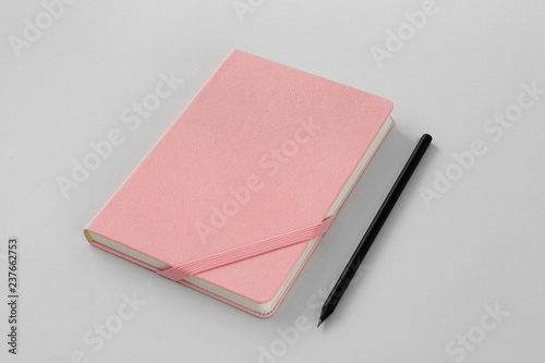 a pink leather note and a pencil