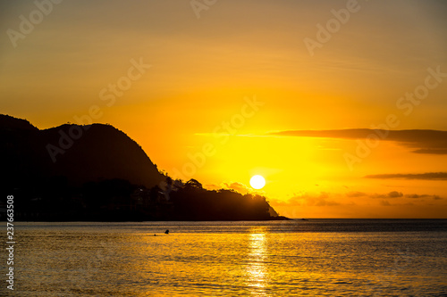 Sunset at Mahe in Seychelles with the sun come behind a mountain in the sea
