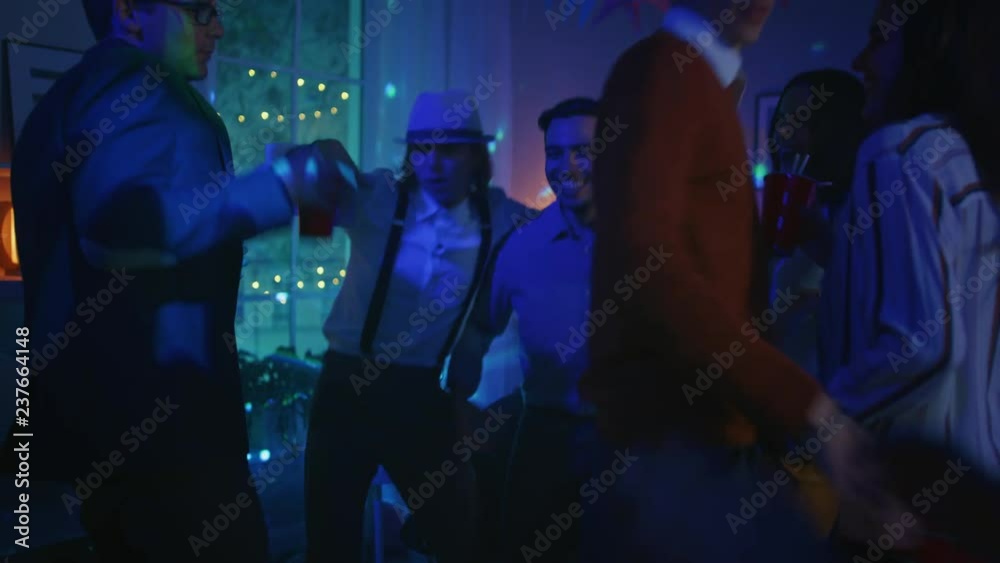 At the House Party: Diverse Group of Friends Have Fun, Dance, Jump, Socialize and Drink. Stylish Young People Clubbing. Disco Neon Lights. At the House Party: Diverse Group of Friends Have Fun, Dance, Jump, Socialize and Drink. Stylish Young People Clubbing. Disco Neon Lights.