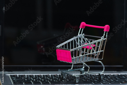 Shopping cart or supermarket trolley with laptop notebook, e-commerce and online shopping concept.