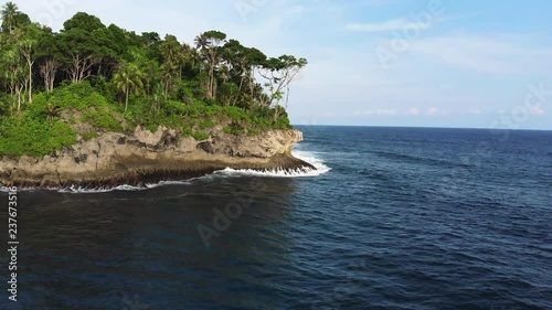 Drone elevating above waves and surfers in a beach cove called Wong Tong. Most consistant reef break in the area on the remote island of Simeulue, off the coast of North Sumatra in Indonesia. photo