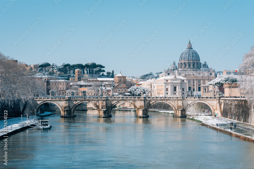 Ponte Sant'Angelo and St. Peter's Basilica in the snow, in Rome, Italy.