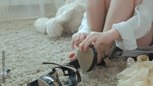 cheerful girl with pigtails trying on adult mother's clothes, dresses, high heels, mothers wardrobe, close-up of legs