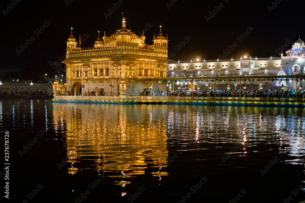 Colorful and illuminated golden temple and its reflection