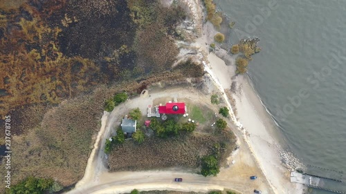 Lighthouse and shore filmed by ascending drone. photo