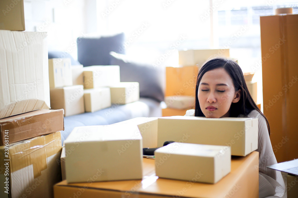 Tired unhappy of Young asian girl is freelancer Start up small business owner writing address on cardboard box at workplace,Shipping shopping online small business entrepreneur SME or freelance Tired unhappy of Young asian girl is freelancer Start up small business owner writing address on cardboard box at workplace,Shipping shopping online small business entrepreneur SME or freelance