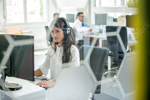 Through glass view of call center worker at office.