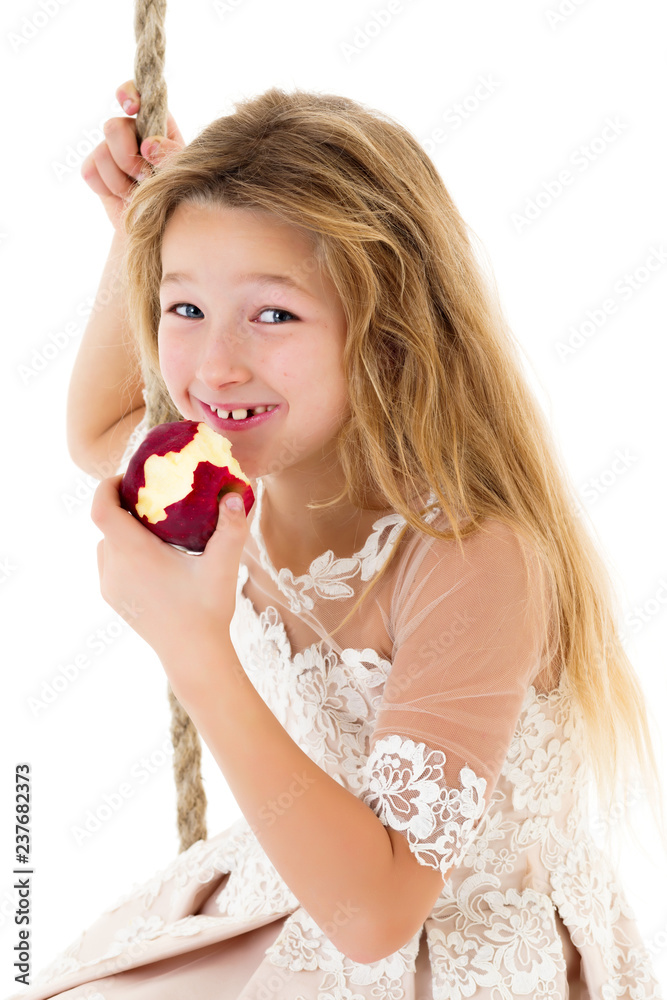 Little girl on the swing eating an apple. Little girl on the swing eating an apple.