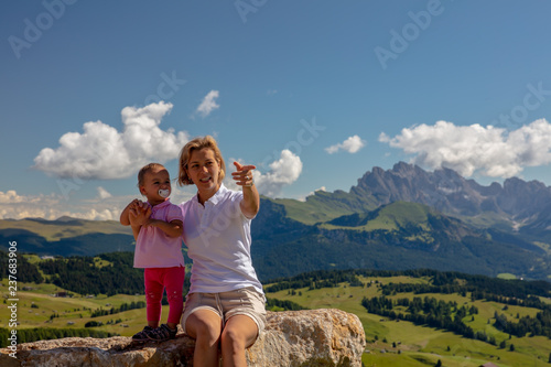 Mother and her toddler enjoying the fresh air and sun set into a stunning Seiser Alm panorama