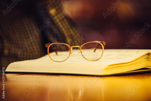 Golden luxury glasses on book lying on library table