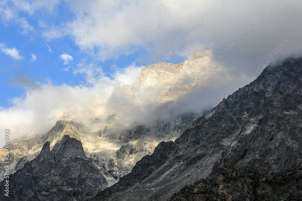 Peak of snow capped mountain poking through the clouds in Caucasus