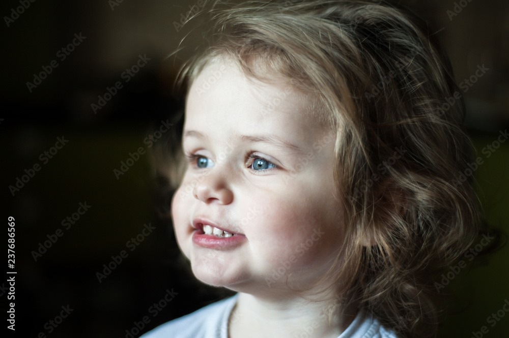 Closeup portrait of a child. Profile. Shows teeth. Shaggy girl. Emotional concept Closeup portrait of a child. Profile. Shows teeth. Shaggy girl. Emotional concept