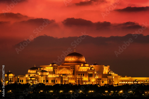 Beautiful sunset over the uae presidential palace in Abu Dhabi. The clouds look like mountains in the background. photo