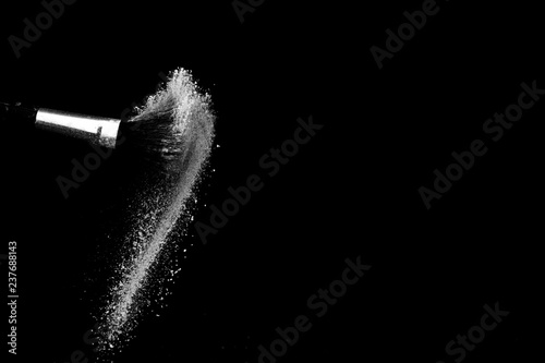 white powder splash and brush for makeup artist or beauty blogger in black background