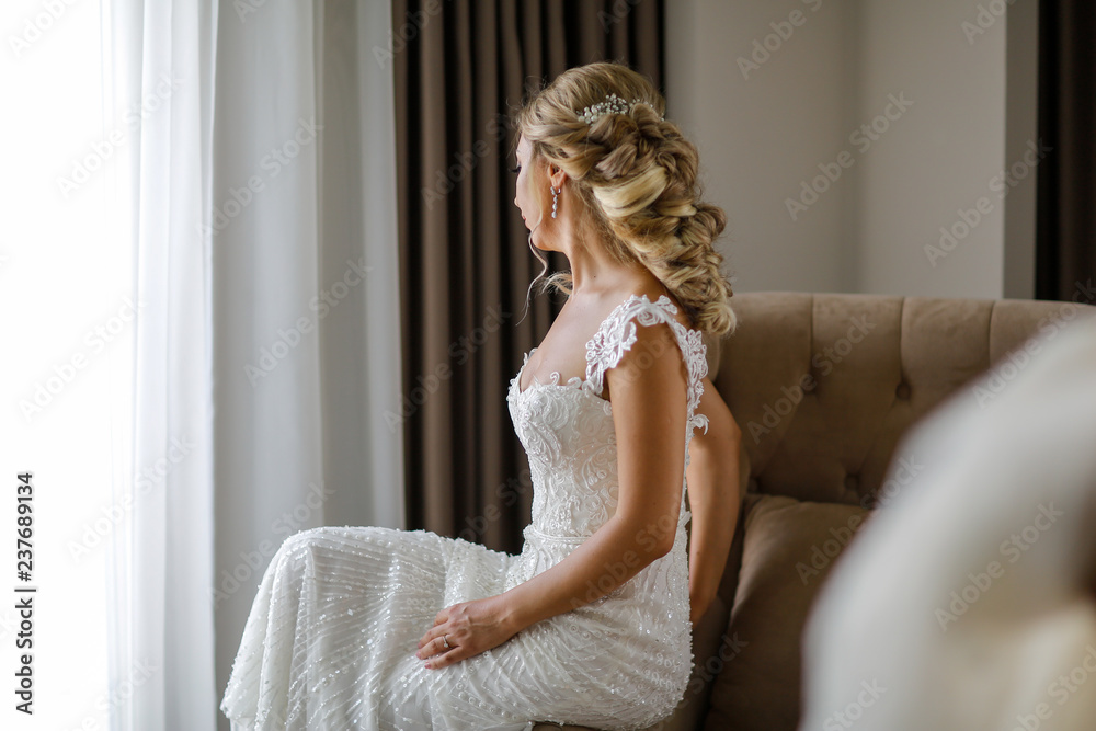 Beautiful blonde bride posing in luxury room