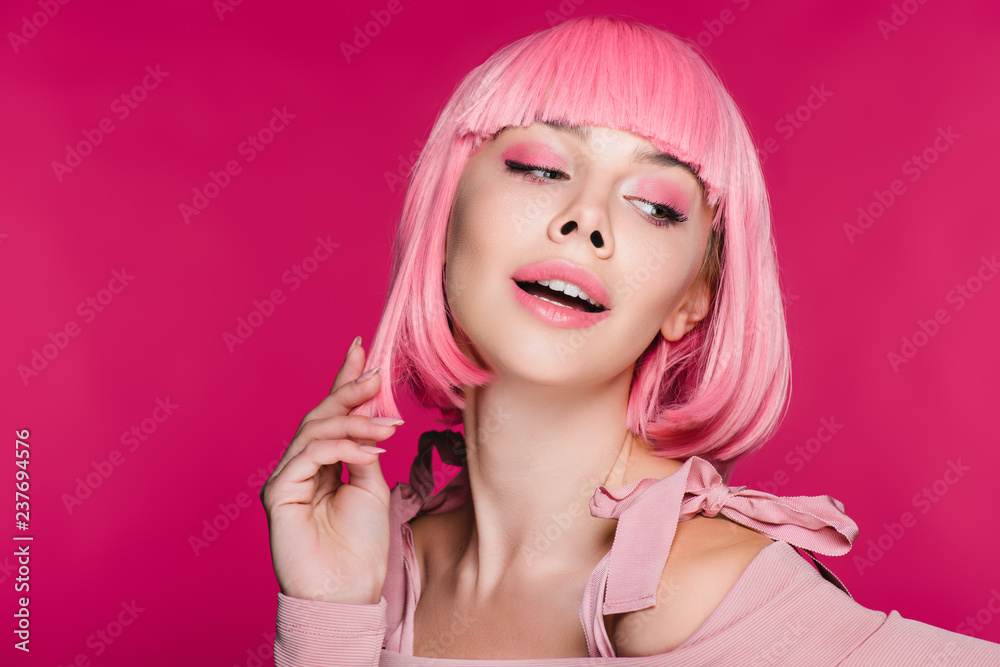 sensual stylish girl posing in pink wig, isolated on pink sensual stylish girl posing in pink wig, isolated on pink
