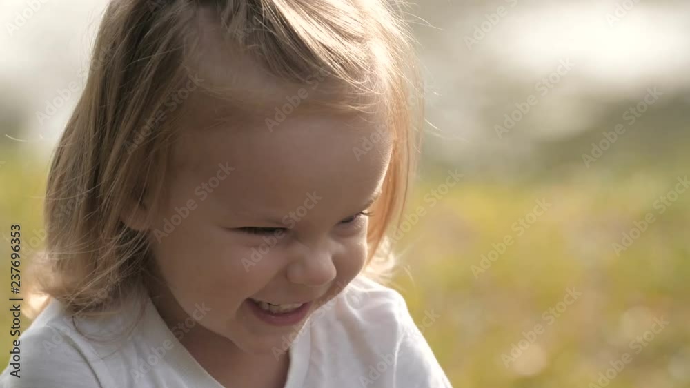 Portrait of smiling baby with soap bubbles looking at the camera in the summer park in sunset light. Portrait of smiling baby with soap bubbles looking at the camera in the summer park in sunset light.