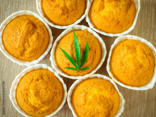 Delicious homemade baked cinnamon muffins with marijuana leaf garnish. Cookies with cannabis and buds. Treatment of medical marijuana for use in food.