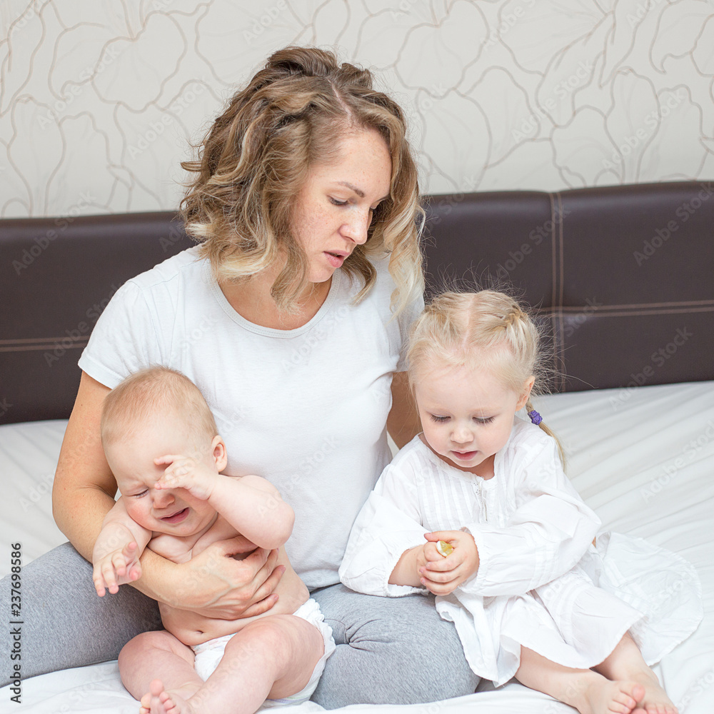 Young tired mother with her two kids Young tired mother with her two kids