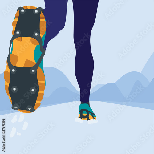 Woman is running during winter training outside in cold snow weather. Sneakers with ice cleats for running on snow and ice.