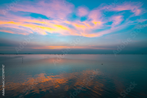 Beautiful sunset sky over the sea in the evening. Blue sky and purple, orange, and yellow clouds. Dramatic sky and clouds at the beach in Tropical sea at dusk. Seascape with sweet sky. Calm and relax