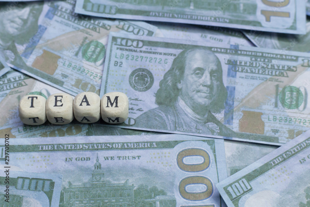 Fototapeta premium Team word on wood brick background banknote..