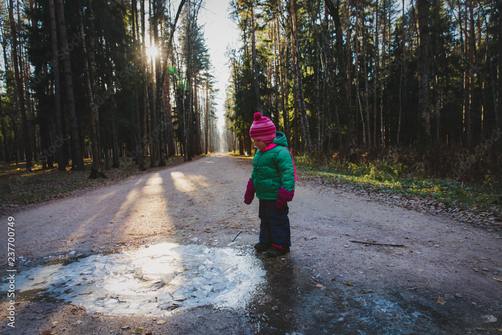 little girl looking at first snow and ice