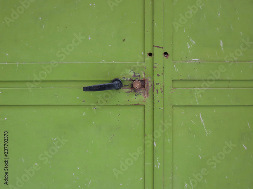 green iron garage door with handle and lock