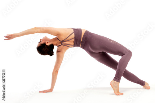 Young beautiful yoga woman is posing in studio on white background