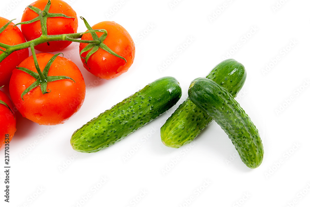 Bunch of red tomatoes and several green cucumbers on the white background. Bunch of red tomatoes and several green cucumbers on the white background.
