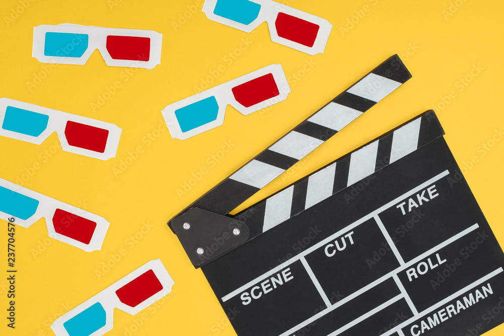 plastic 3d glasses and clapperboard isolated on yellow