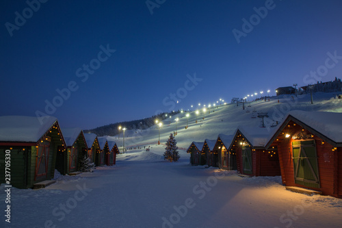 winter market village in Levi, Finland in the evenig on ski cable way background