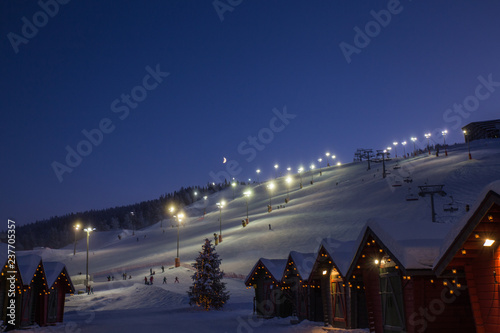 winter market village in Levi, Finland in the evenig on ski cable way background