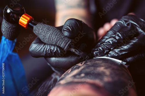 Tattoo artist makes a tattoo on a man's hand