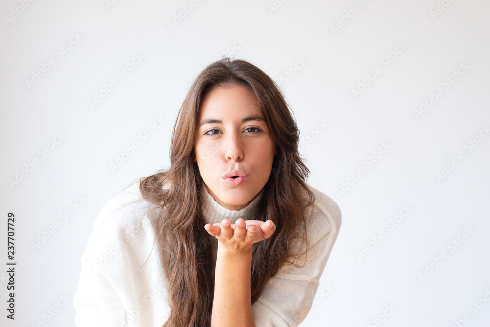 Pretty cheerful Hispanic girl blowing kiss from hand. Stylish young woman. Isolated on white. Love concept Pretty cheerful Hispanic girl blowing kiss from hand. Stylish young woman. Isolated on white. Love concept