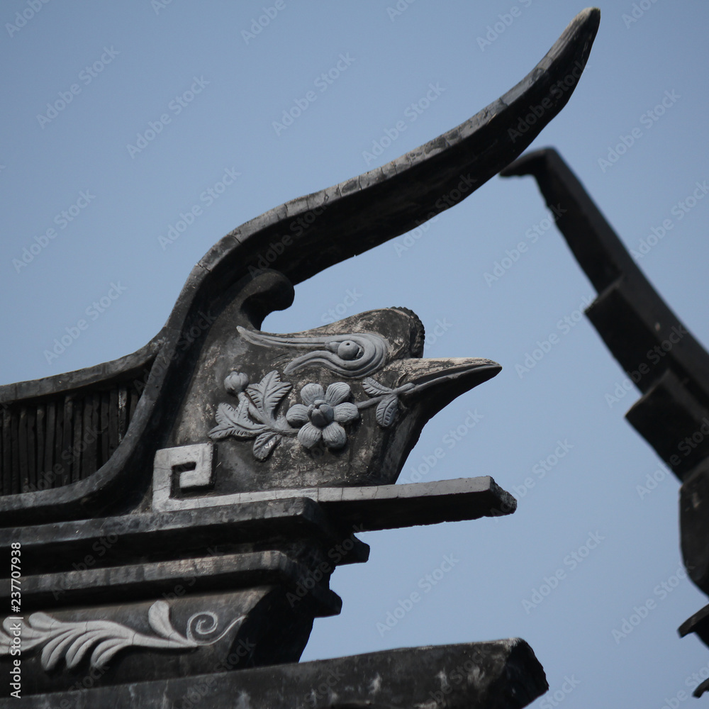 Roof top stone carving decoration showing a bird in the old town in Suzhou city, China, Asia