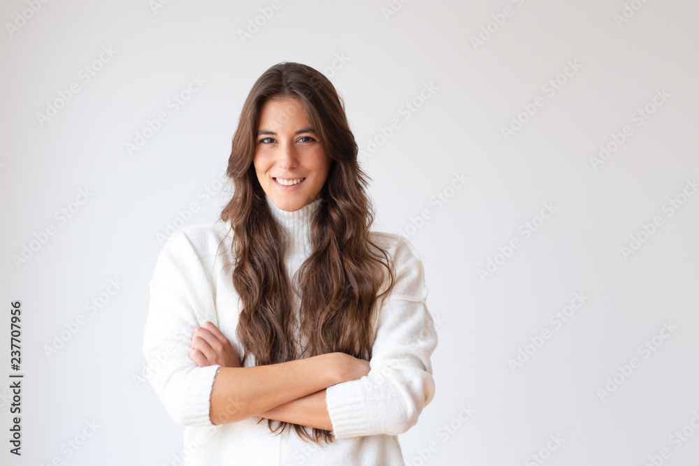 Successful Hispanic young woman with crossed arms looking at camera. Portrait of beautiful smiling girl with long hair. Isolated on white. Confidence concept Successful Hispanic young woman with crossed arms looking at camera. Portrait of beautiful smiling girl with long hair. Isolated on white. Confidence concept