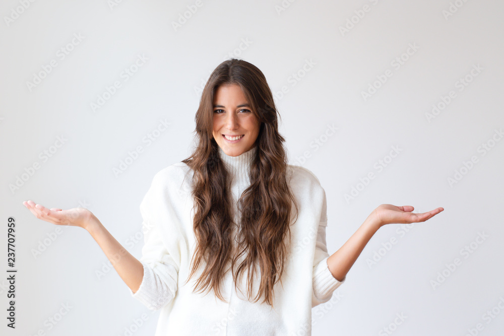 Smiling Latin woman with shrug gesture asking something and looking at camera. Portrait of cheerful girl in white sweater. Isolated on white. Question concept Smiling Latin woman with shrug gesture asking something and looking at camera. Portrait of cheerful girl in white sweater. Isolated on white. Question concept