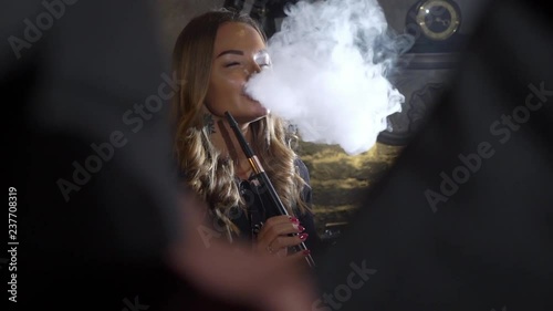 Hookah smoker. Young woman smoking shisha or hookah in cafe or bar. Resting in shishabar lounge. photo