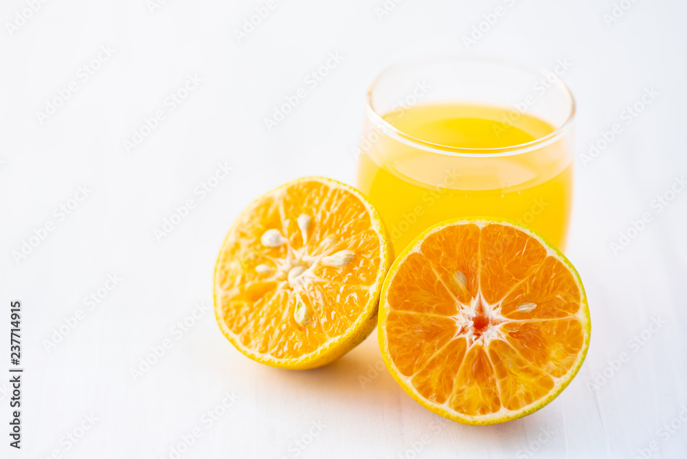 Fresh tangerine orange fruit and juice on white table Fresh tangerine orange fruit and juice on white table