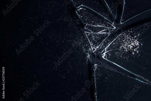 A broken glass on a black surface, with many sharp shards creating a white irregular textured pattern. Useful texture overlay.
 photo